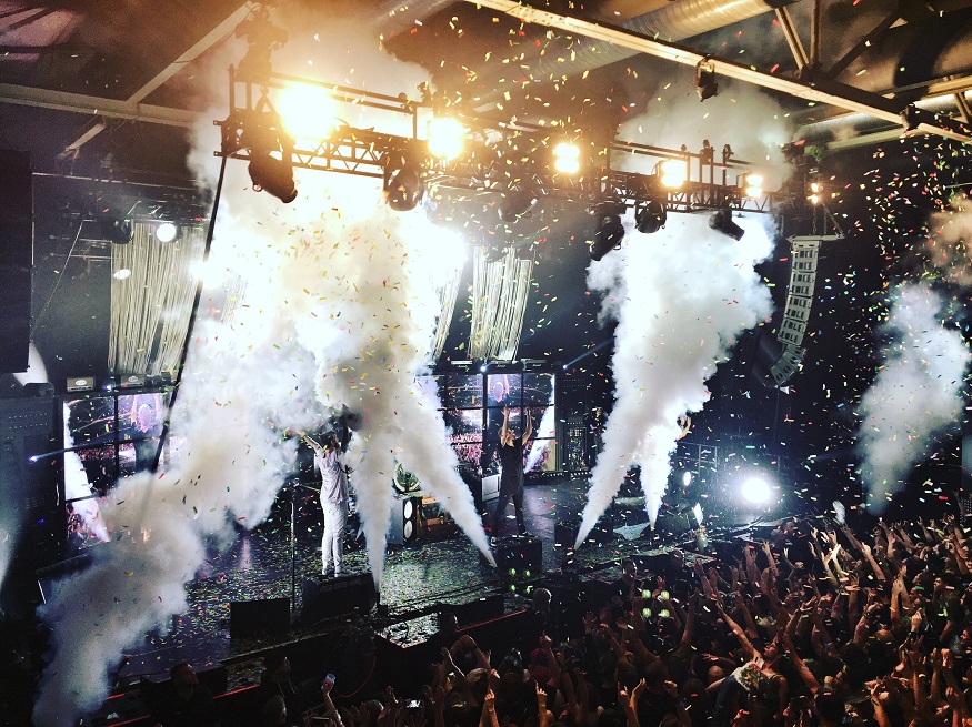 best cities for new year, club in berlin with smoke machine and confetti over the crowd