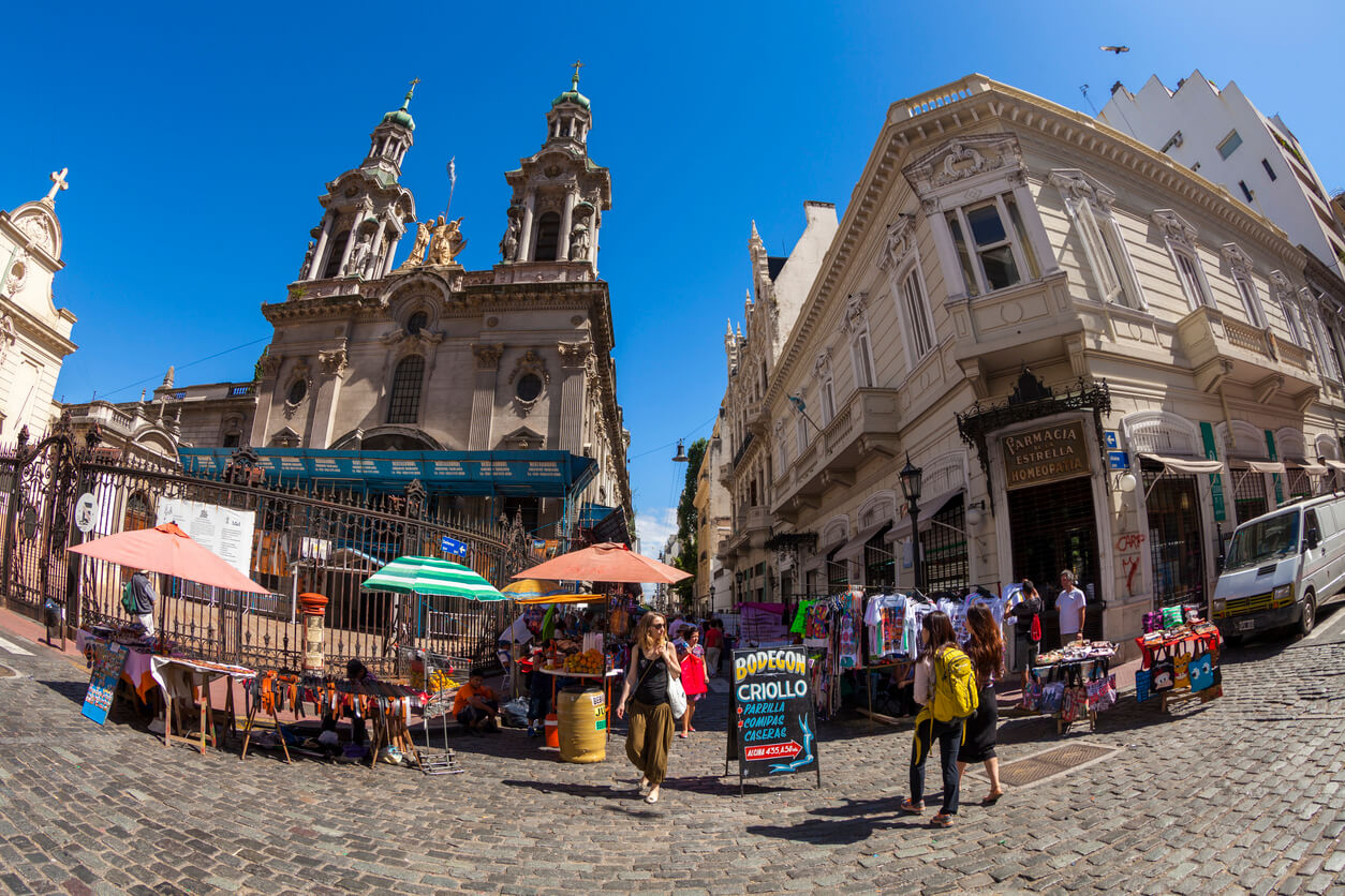 Buenos Aires, Argentina - January 21, 2013: San Pedro Gonzales Telmo Parish Church surrounded by stalls that are part of the San Telmo Sunday Market. People can be seen entering and leaving the market place. The image is taken with a fisheye lens.