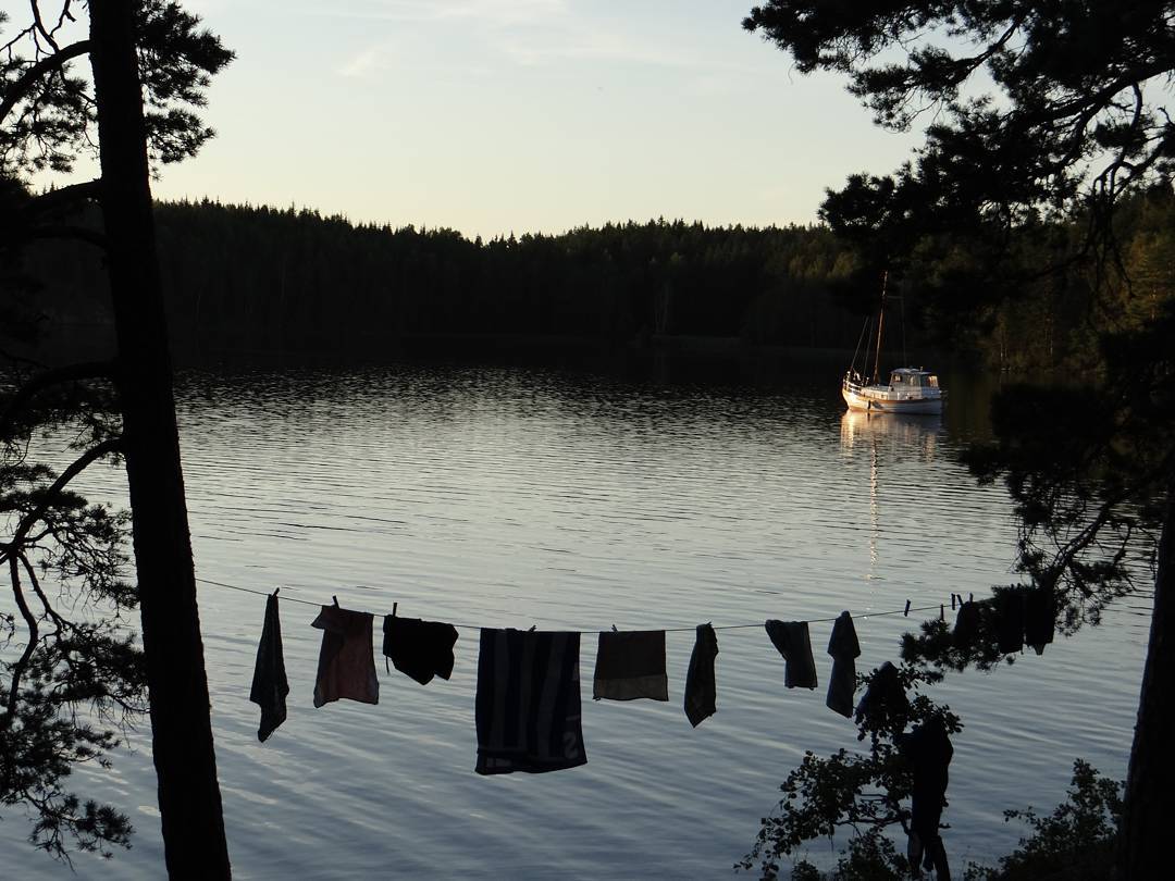 Boat on the lake and makeshift washing line next to a campsite in Sweden’s Lake District