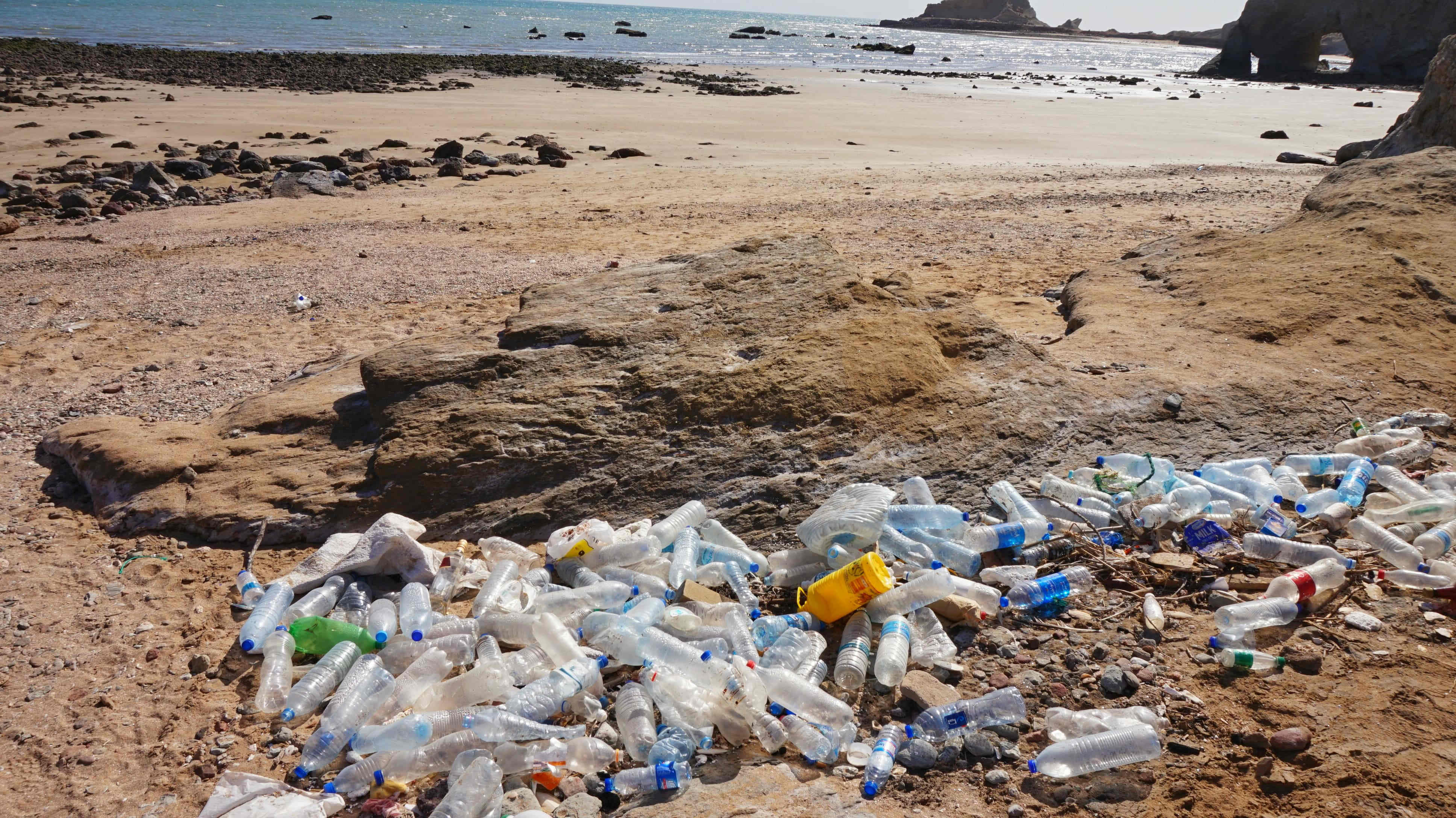 plastic bottles on beach - Green travel tips
