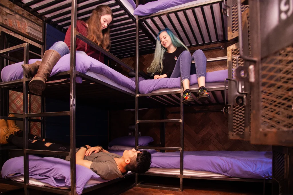 group of people talking in a hostel bunk bed room
