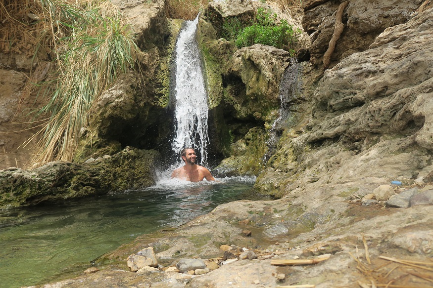 backpacking jordan - man bathing under a waterfall