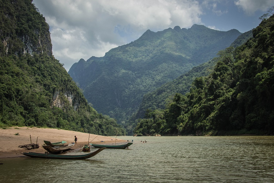 backpacking Laos - canoes in river surrounded by mountains
