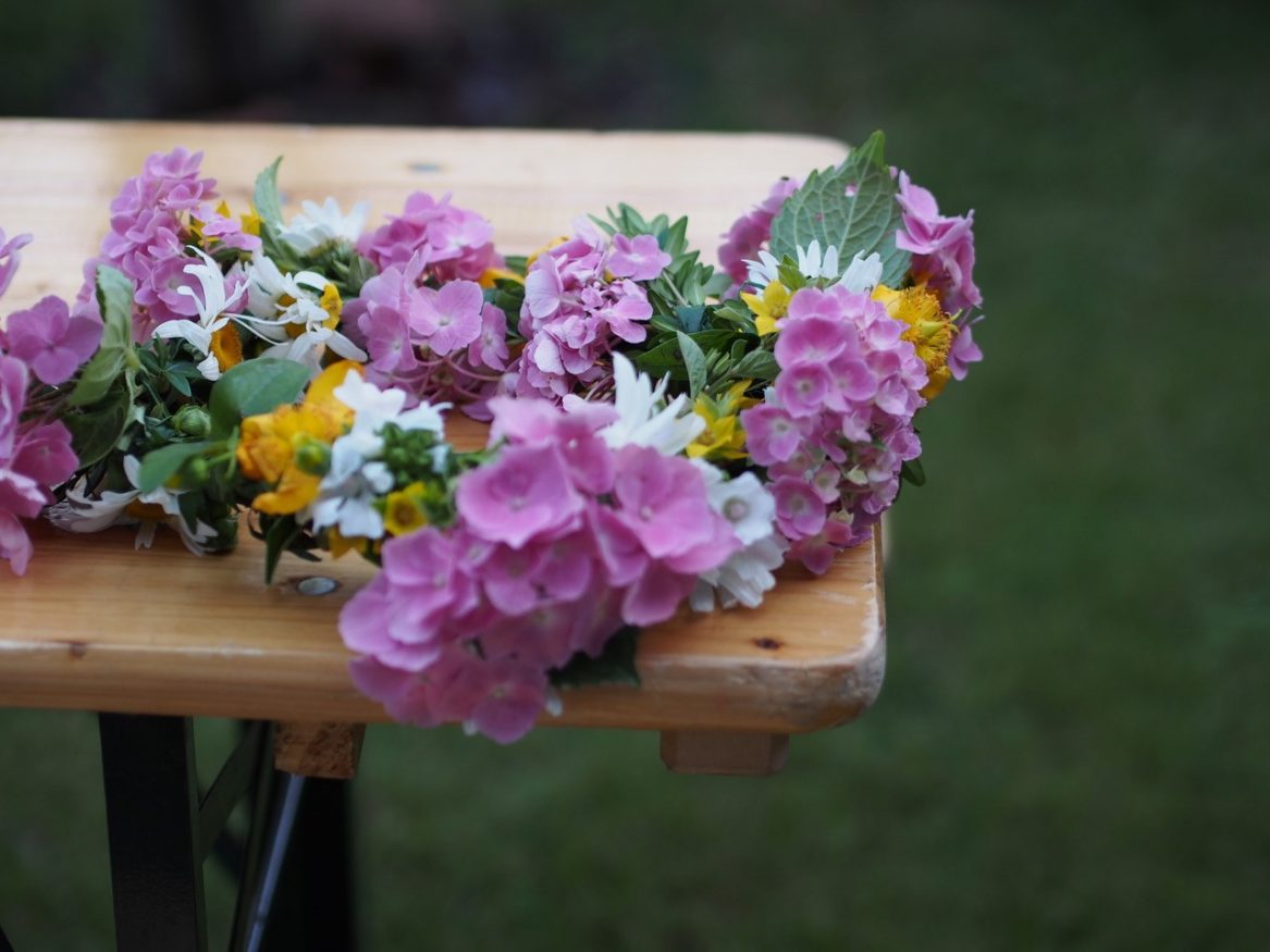 Mittsommer Schweden - Schwedischer Blumenkranz auf einer Holzbank