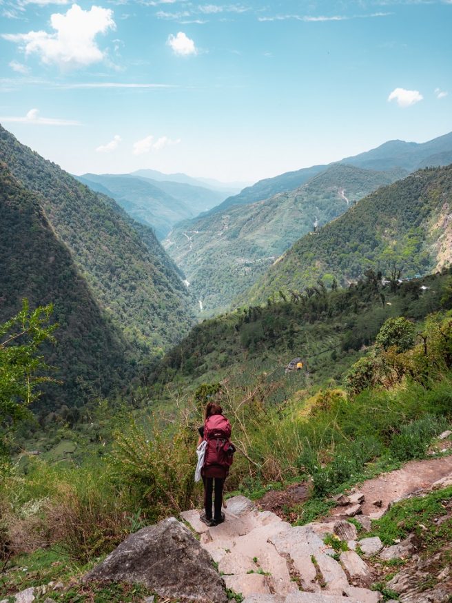 nepal trekking - Backpackerin mit Rucksack blickt auf die Berge, das Tal und die Natur hinaus