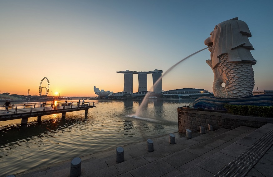 backpacking singapore - fountain spurting water with sunset and marina bay sands hotel in background