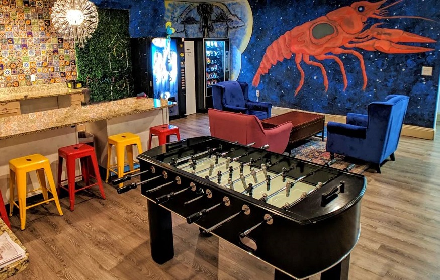 where to stay in new orleans, social area in city house hostel with table football