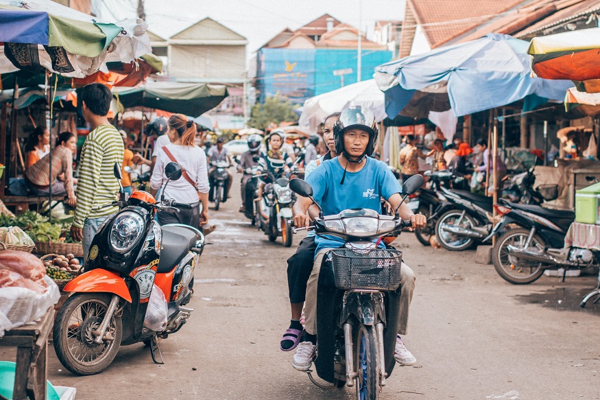 Siem Reap Sehenswürdigkeiten - Mann auf Moped fährt durch den Markt