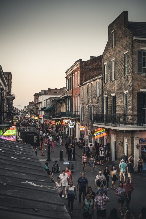where to stay in new orleans, view of the street with people walking from a window above in the french quarter