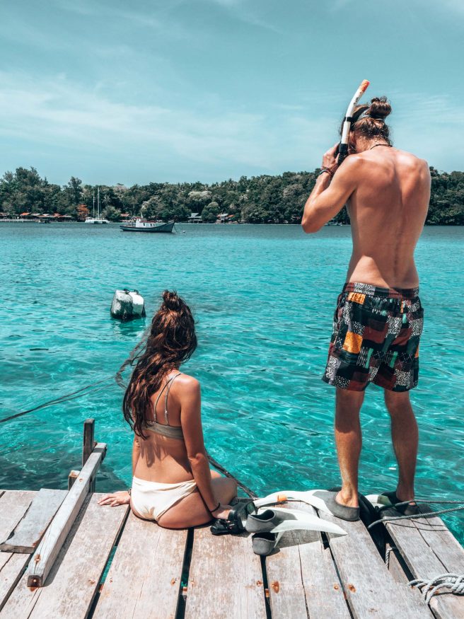 insel sumatra - Junger Mann in Badeshorts bereitet sich darauf vor ins Meer zu springen, um zu schnorcheln