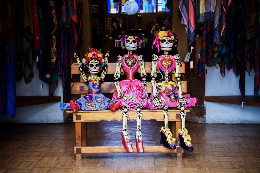 Day of the Dead facts, day of the dead skeleton dolls sitting on a bench