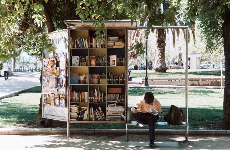 backpacking chile, man sitting on a bench near books in santiago