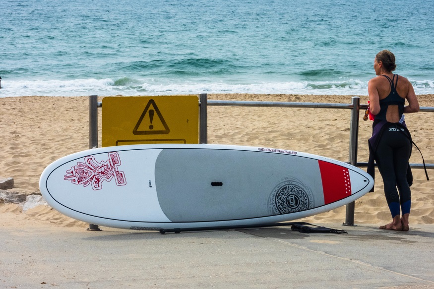bournemouth on a budget, woman standing by surfboard