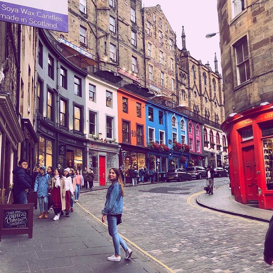 edinburgh on a budget, girl standing in cobbled street by Grassmarket