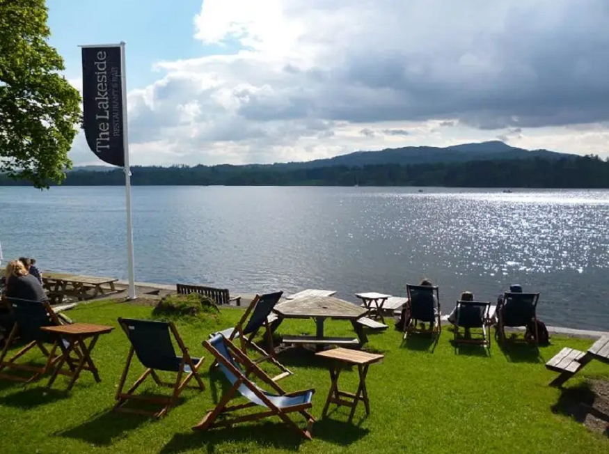 places to go for new years eve uk, deck chairs in front of a lake at YHA Ambleside in the Lake District