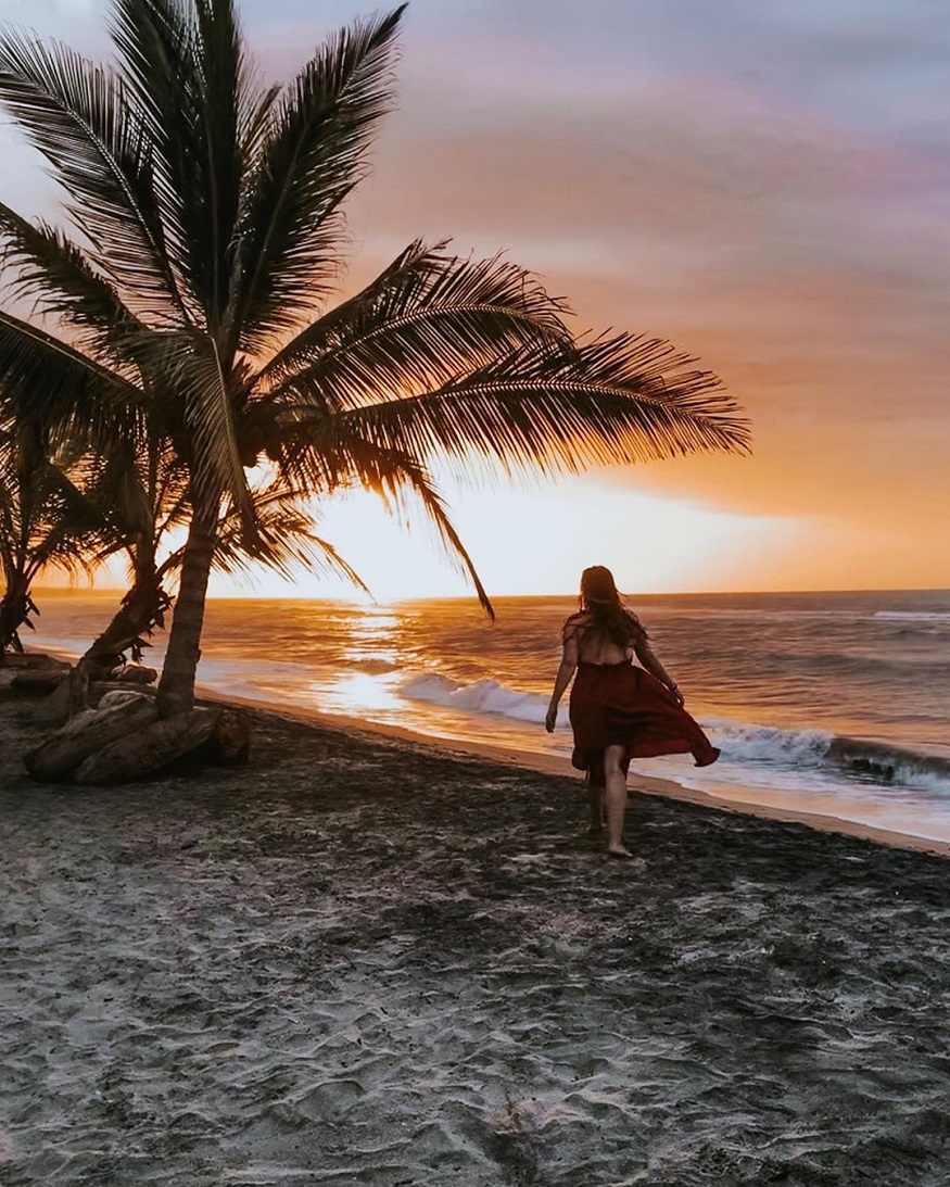 best places to visit in colombia, girl walking on the beach at sunset in tayrona national park