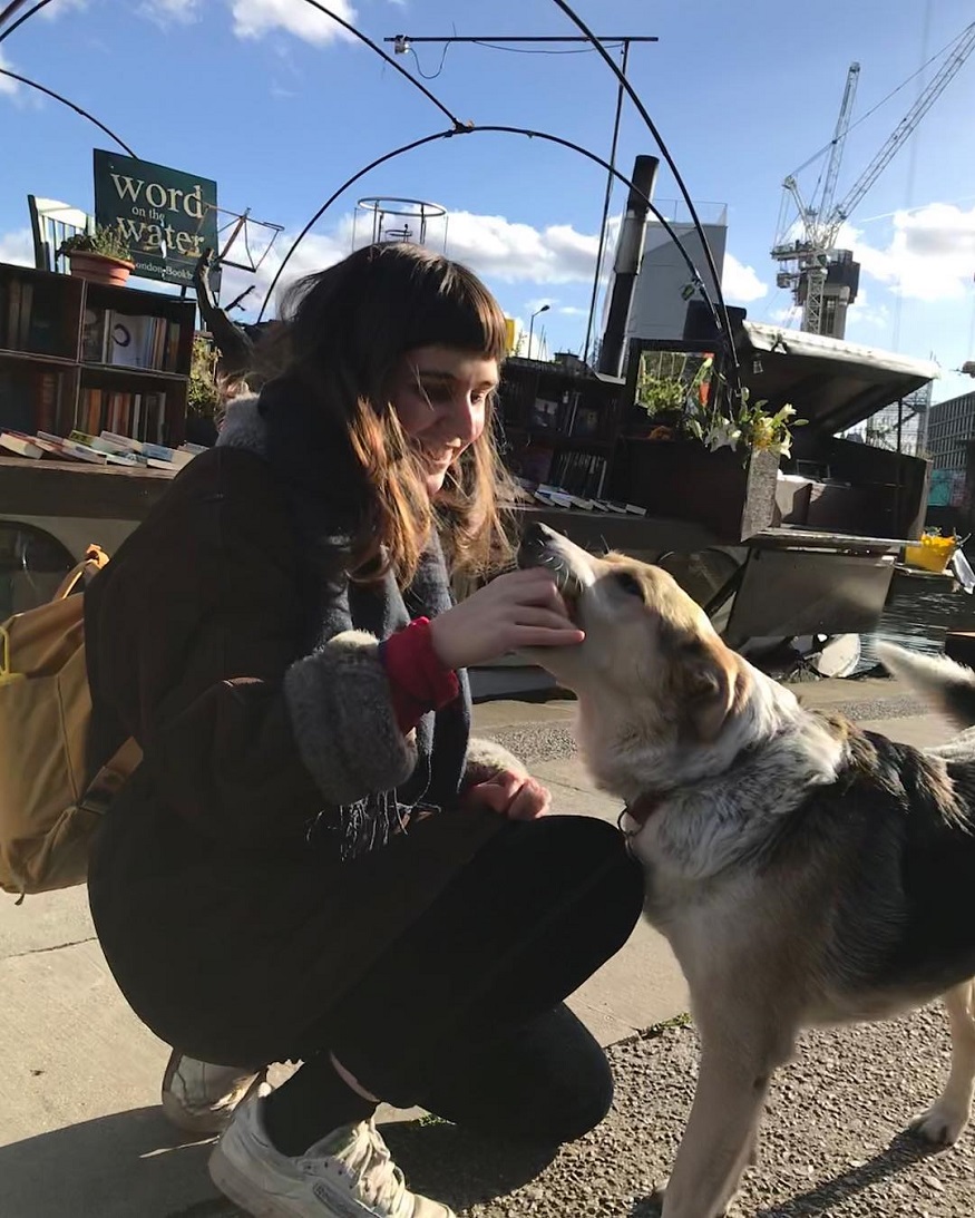 best destinations for book lovers, girl stroking a dog by barge of books