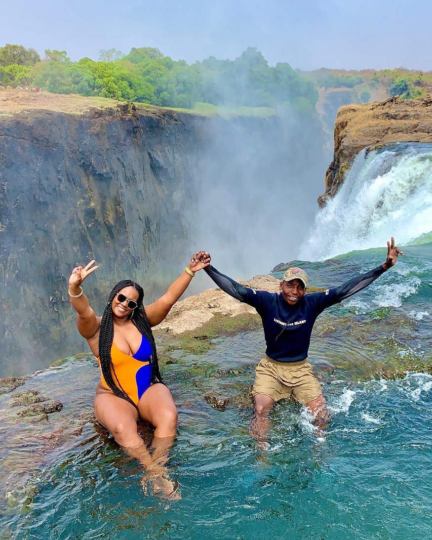 best train journeys, two people sitting Devils Pool at Victoria Falls