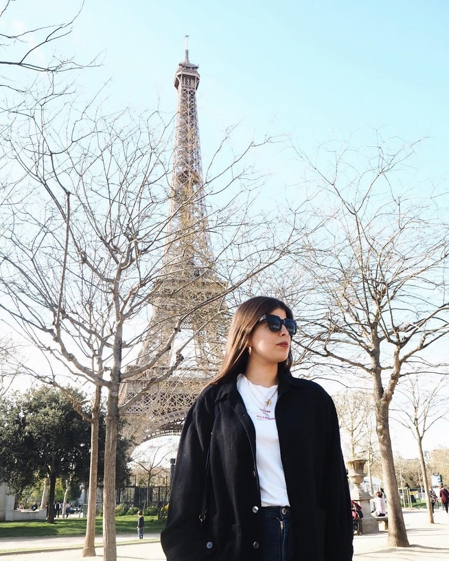 best romantic destinations for solo travellers, girl in sunglasses standing by eiffel tower