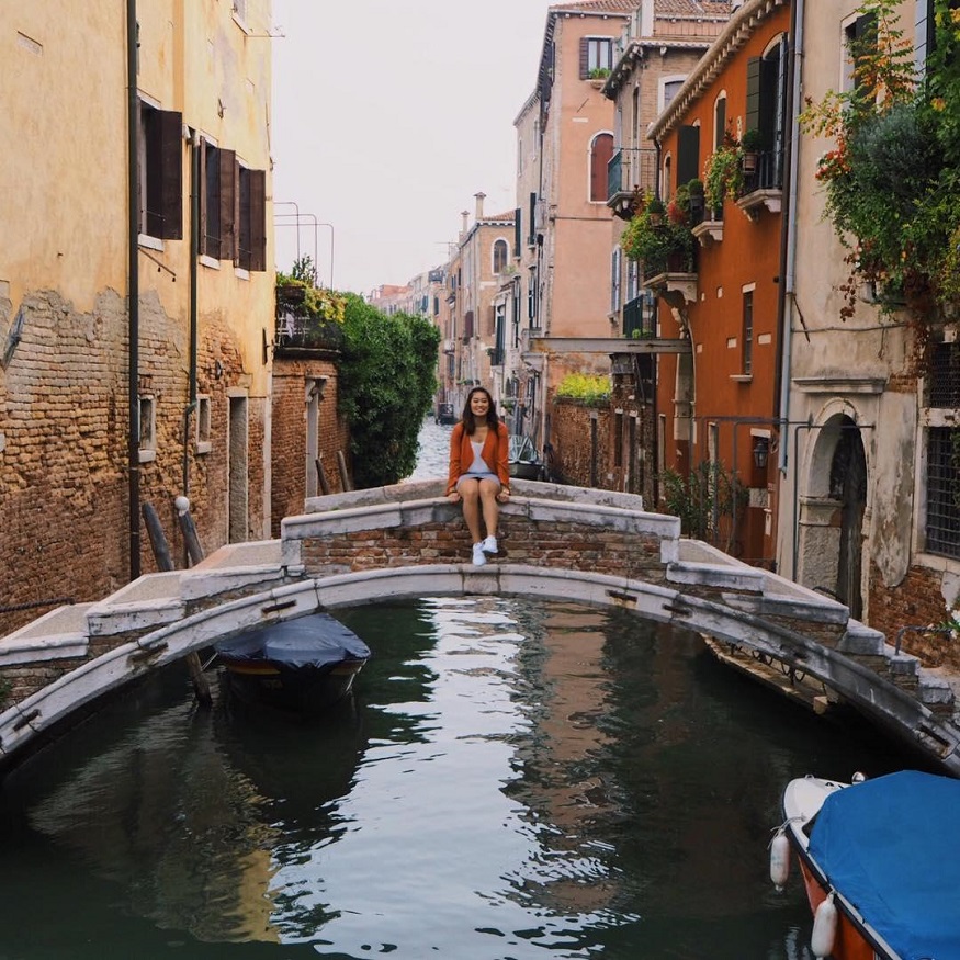 best romantic destinations for solo travellers, girl sitting on bridge in venice