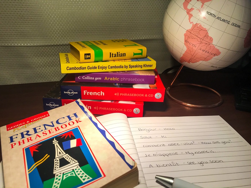 how to cure wanderlust, stack of language books and globe