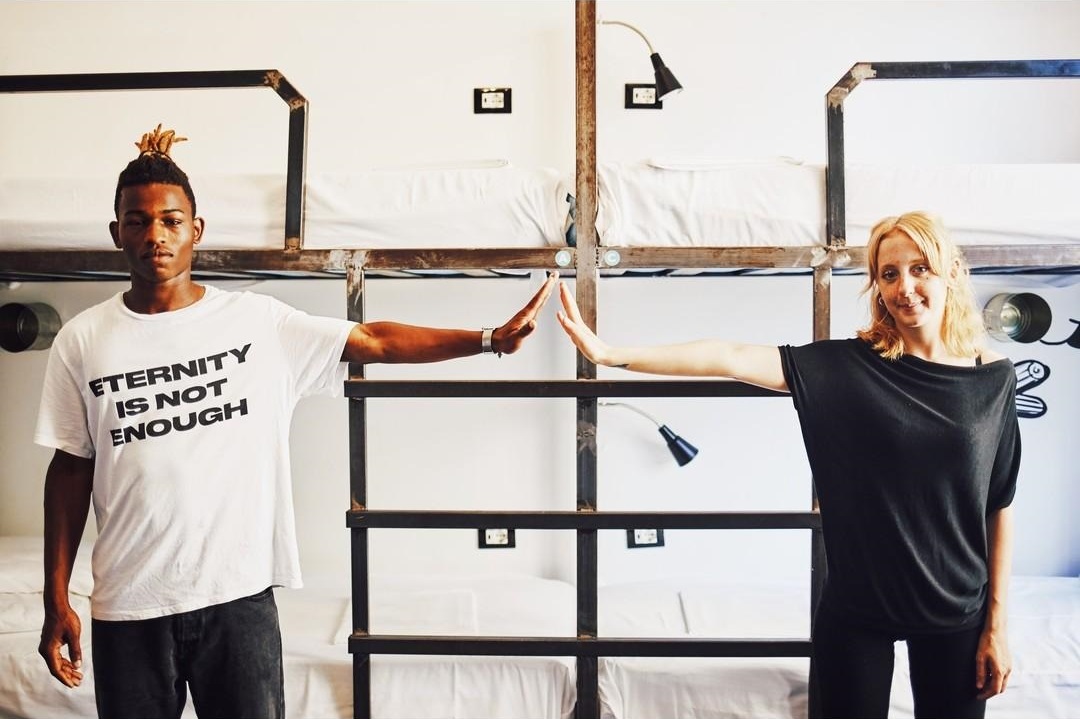 hostels are open - two people standing in a dorm room at madama hostel milano