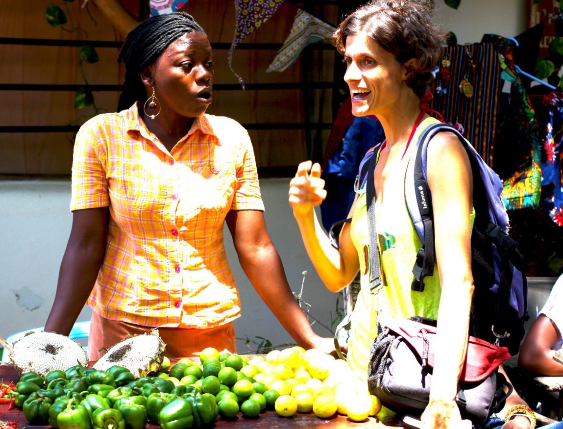 two women chatting by a fruit stand near Distant Relatives Ecolodge & Backpackers hostel ,nominated for extraordinary sustainable hostels