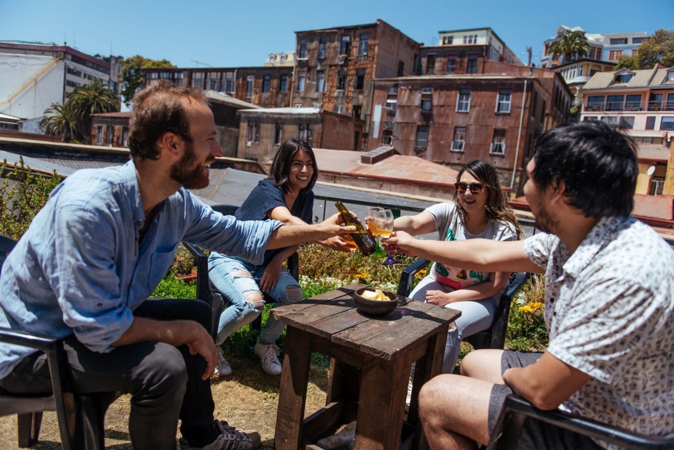 people with beers siting on the rooftop at Maki Hostel Valparaiso - nominated for extraordinary innovation hostels award