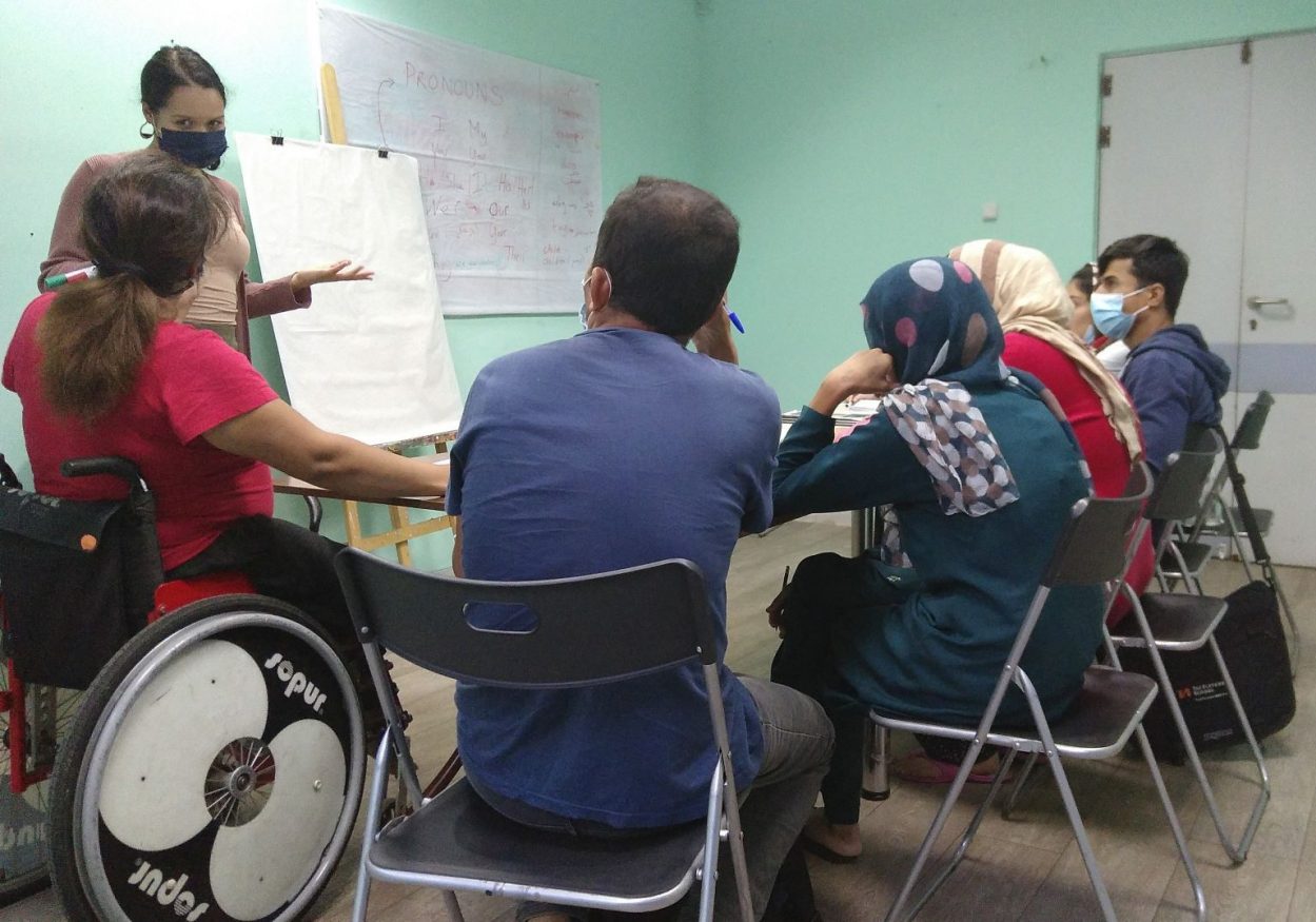people sitting around a table in a meeting at Welcommon Hostel in Greece -nominated for extraordinary hostel heroes award