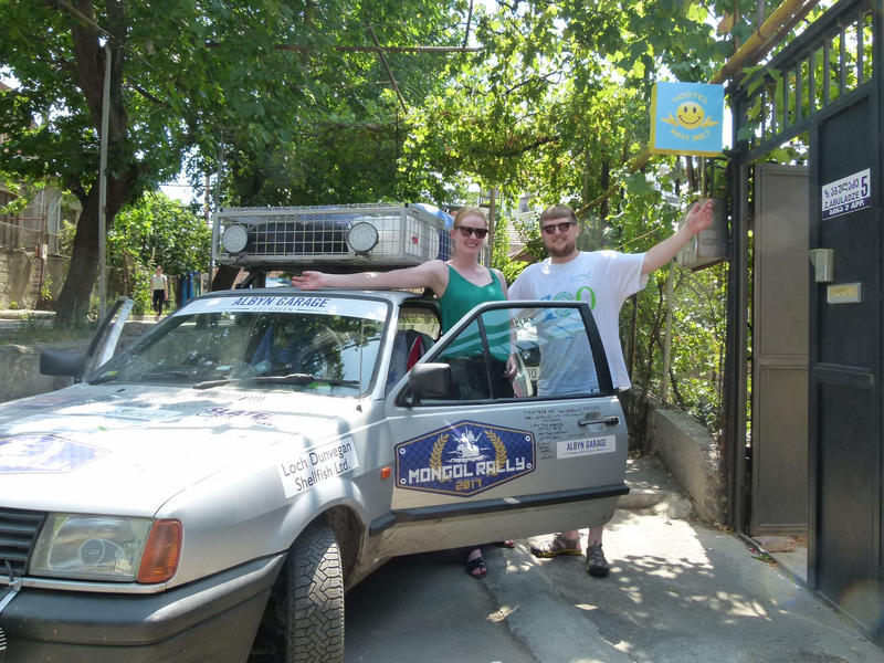 two people standing by their car outside Eco-friendly Why Me Tbilisi hostel in Georgia - nominated for extraordinary innovation hostels award