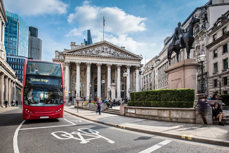 Bus waiting in front of the London Stock Exchange on a sunny day