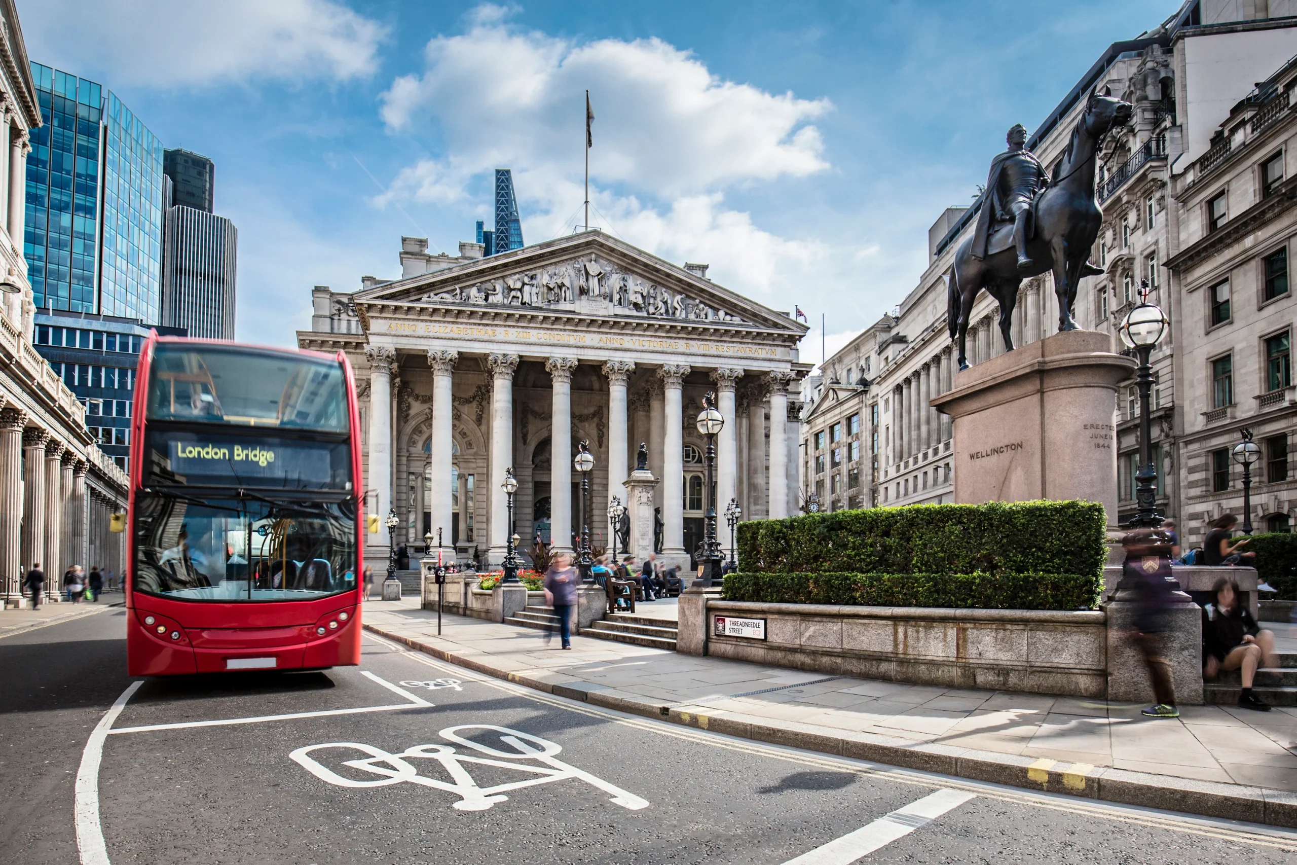Bus waiting in front of the London Stock Exchange on a sunny day