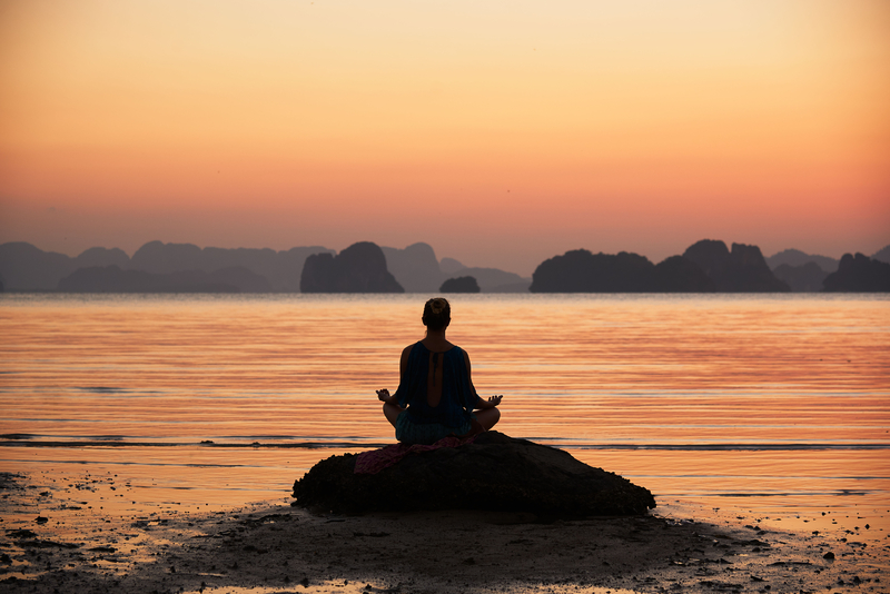 Woman Meditations near Water - Wellness Retreat Solo Travel Ideas