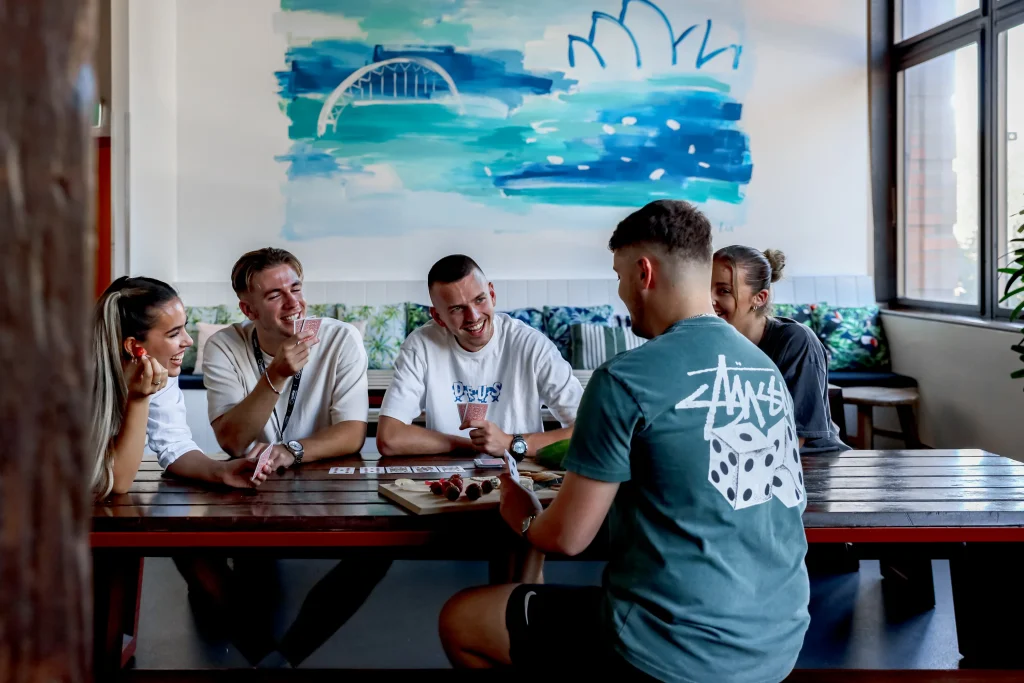 people gathered at a table playing cards