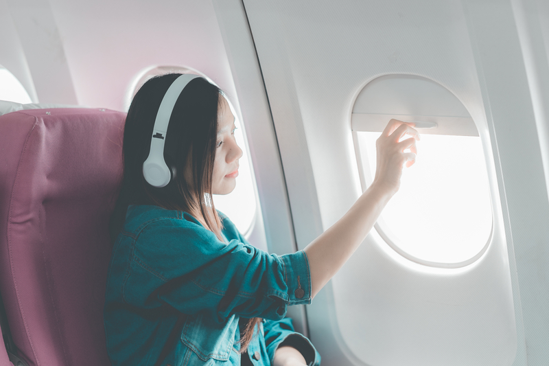Woman Travel by Airplane with Headphones - Essentials Solo Travel