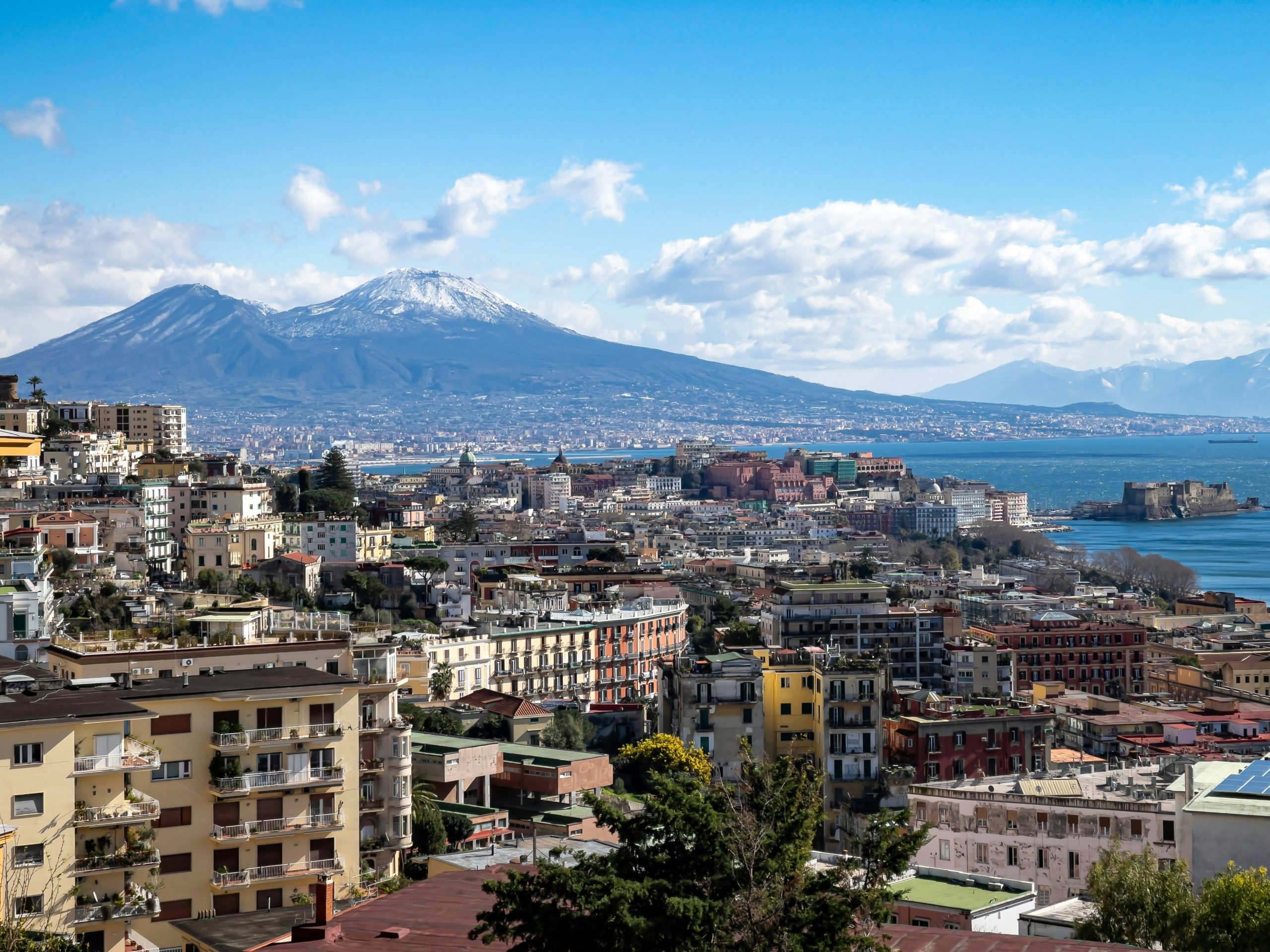 a view of naples with a mountain in the background