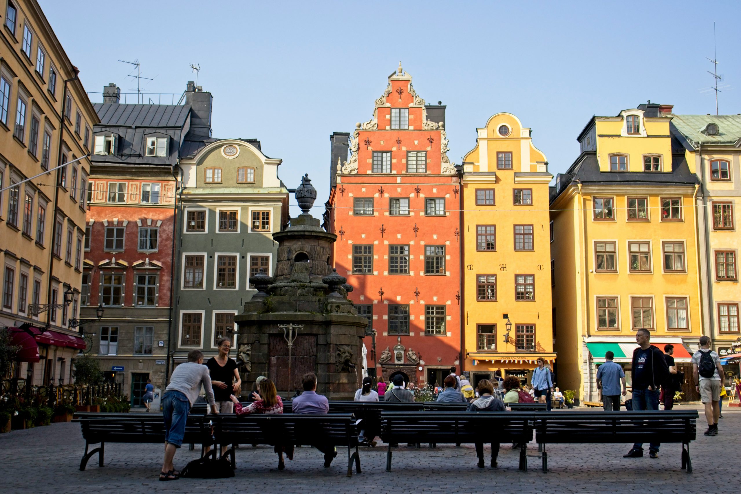 people sitting on a bench in a square in stockholm