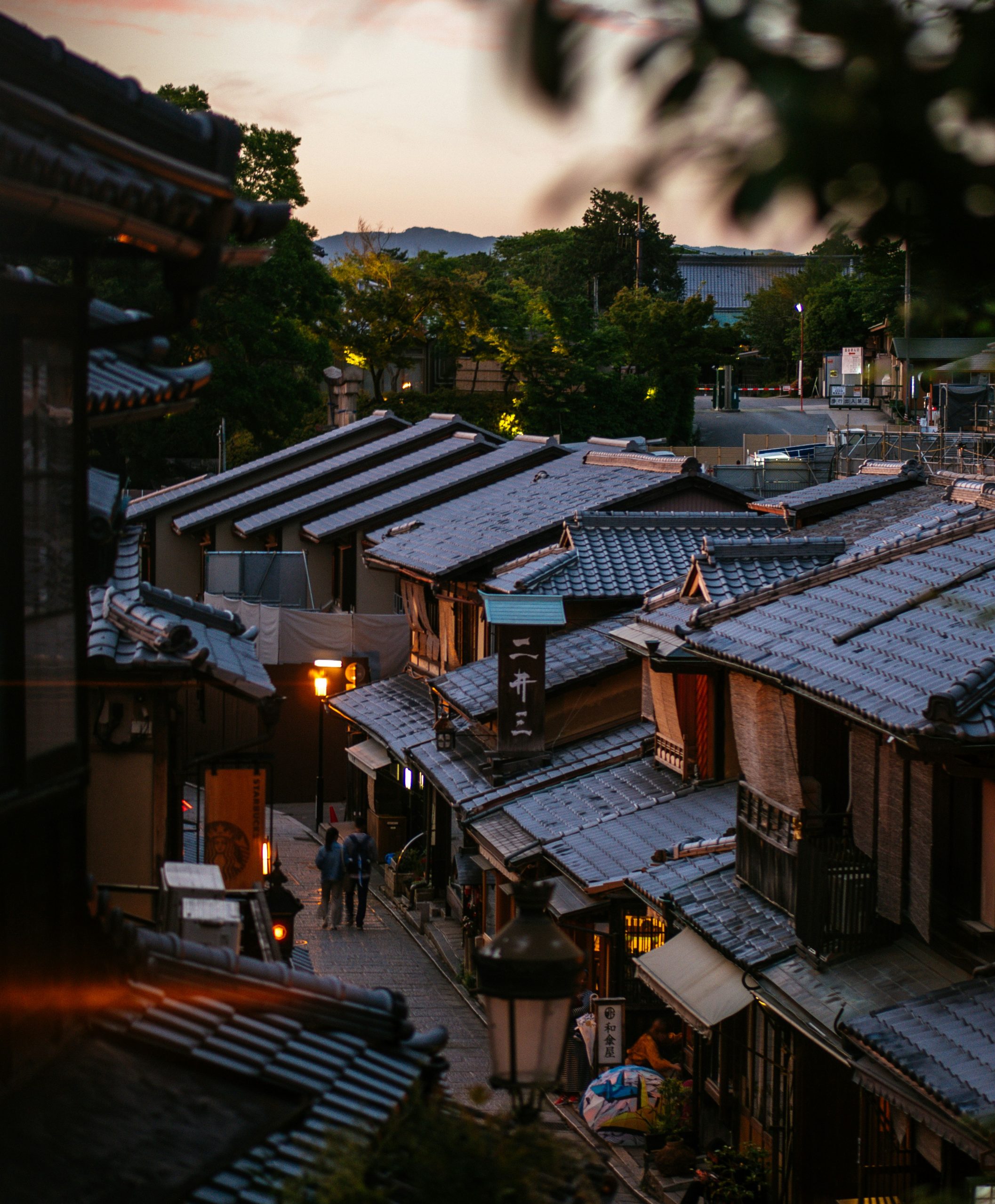 brown wooden houses near green trees during day time in kyoto