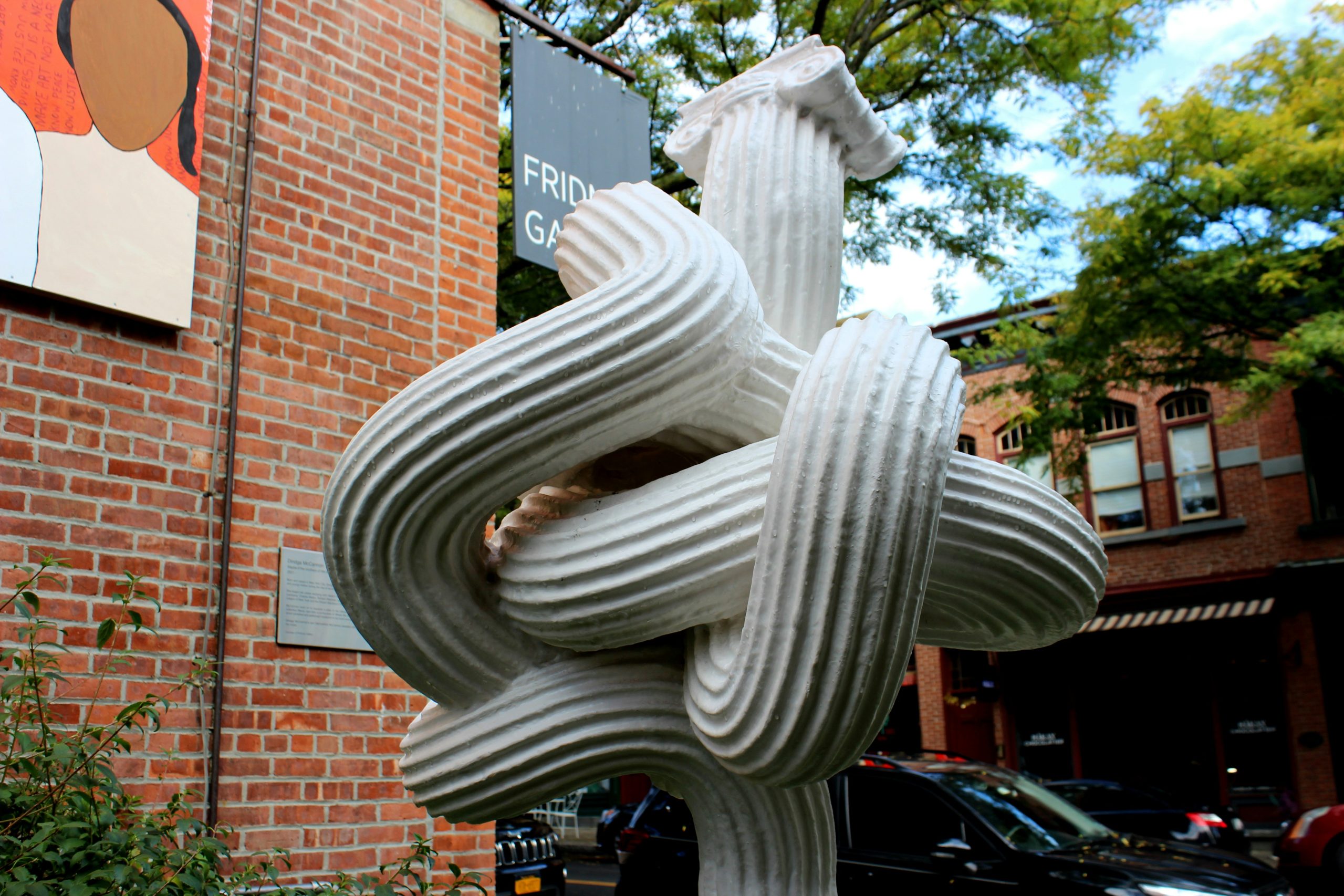  a sculpture of a knot on a post in front of a brick building in beacon, ny, day trips from nyc