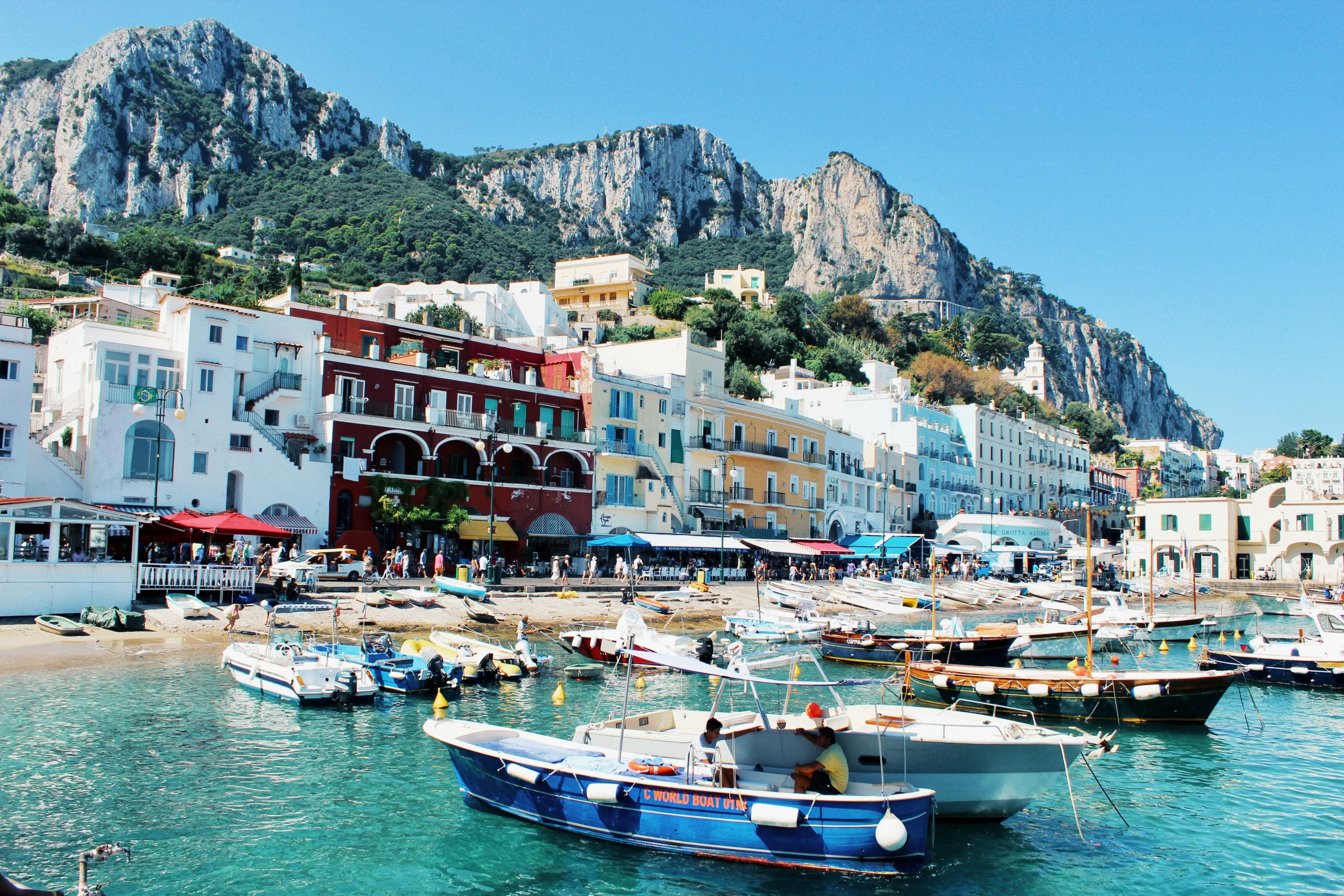 white-and-blue-boat on body of water near buildings during daytime