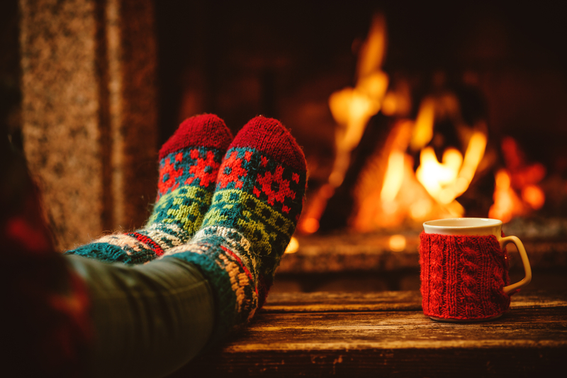 Feet Next to Fireplace at Winter with Hot Drink - Christmas Solo Holidays