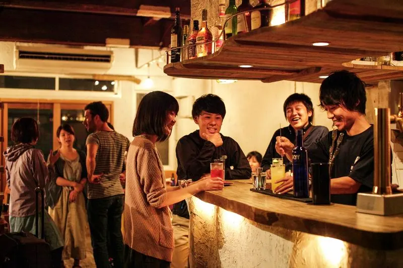 people talking at a bar in a hostel