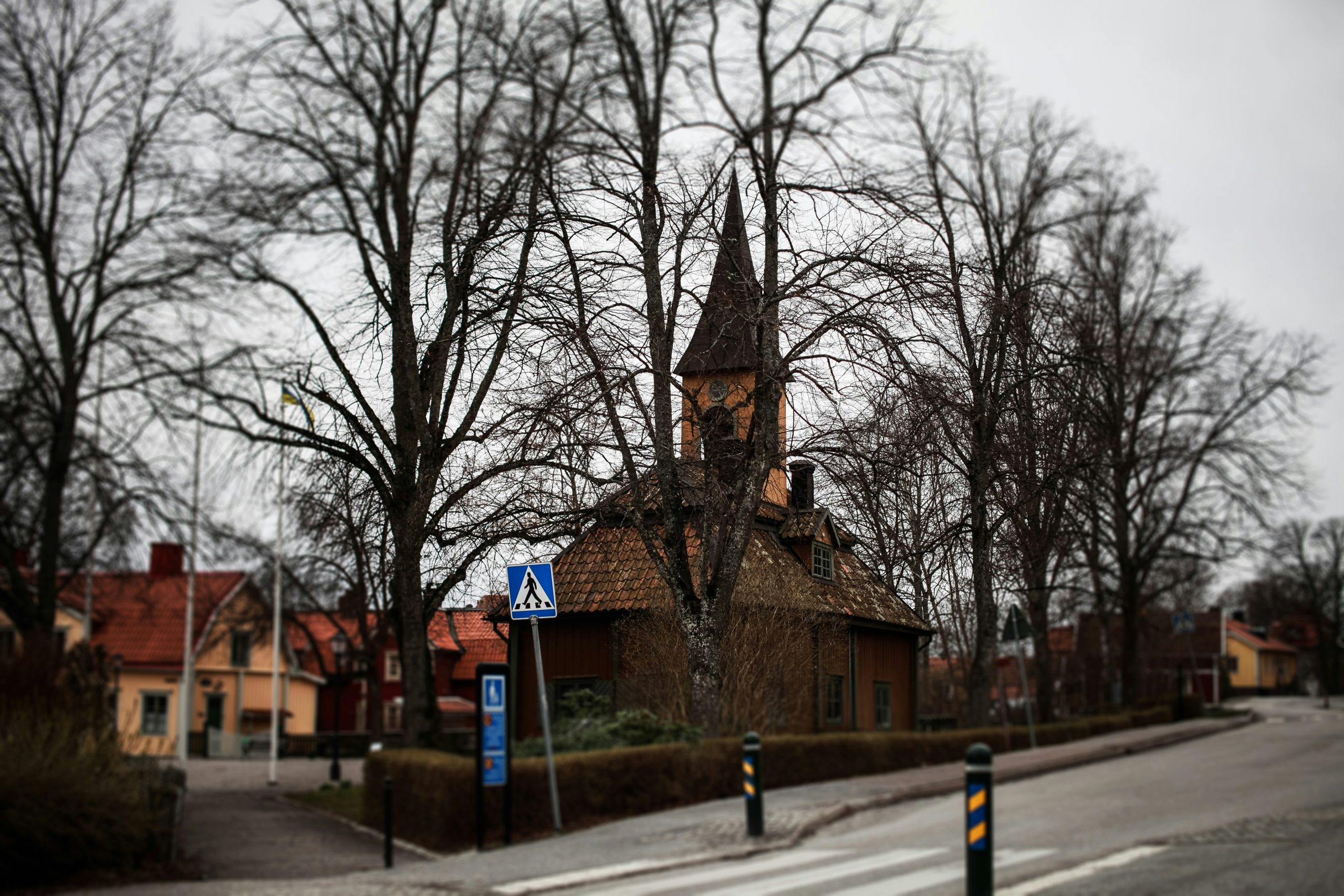 a small church with a steeple on a street corner
