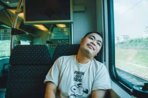 Man travelling in a train looking happy 
