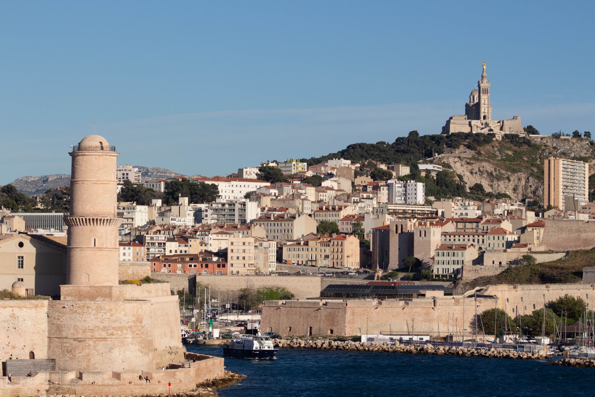 Marsilya'da Saint-Jean Kalesi ve tepedeki Notre-Dame de la Garde Bazilikası