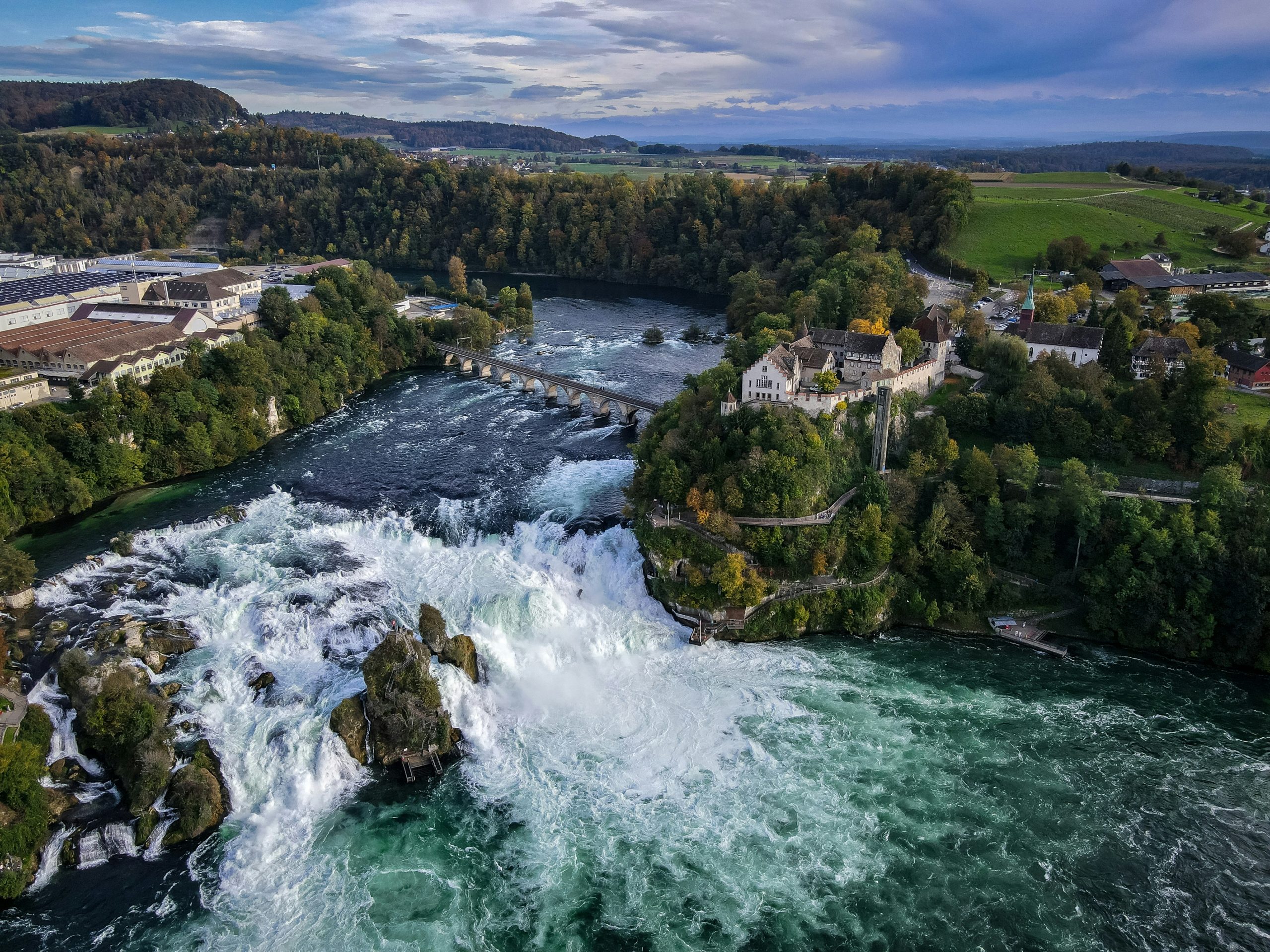 a river running through a lush green forest, day trips from zurich