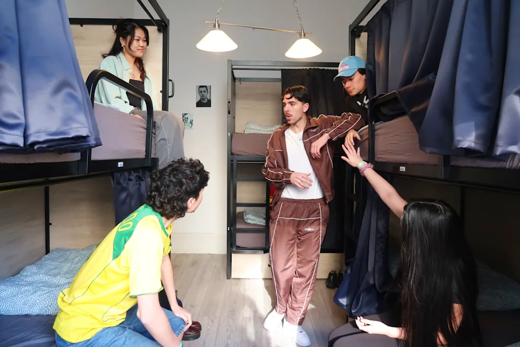 people gathered in a hostel dorm room