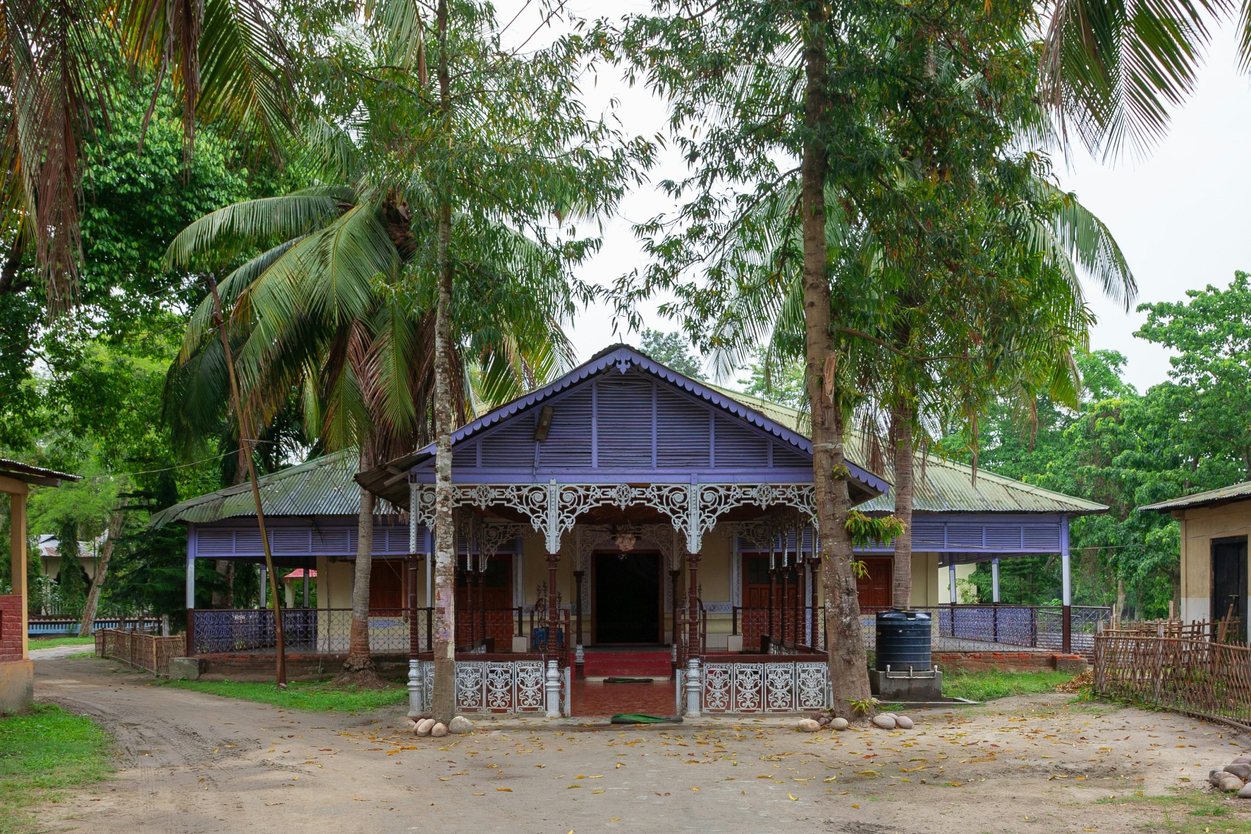 traditional house with purple accents surrounded by trees