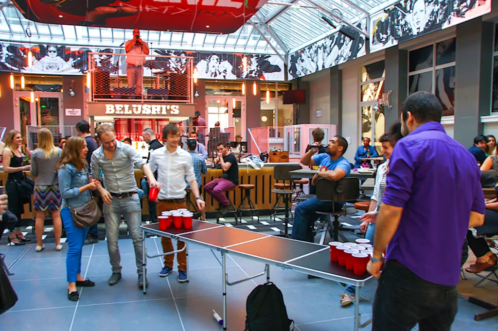 people enjoying a game room with a billiard and bar
