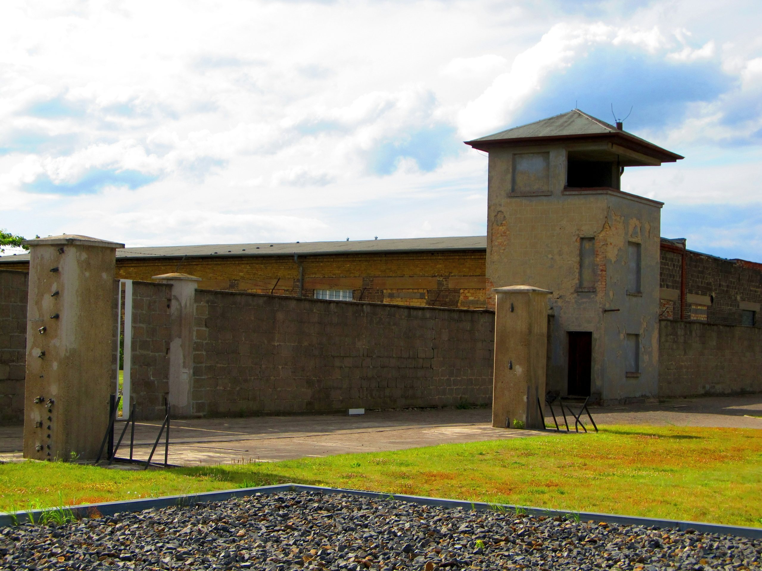 a building with a clock on the front of it, a concentration camp in germany, day trips from berlin